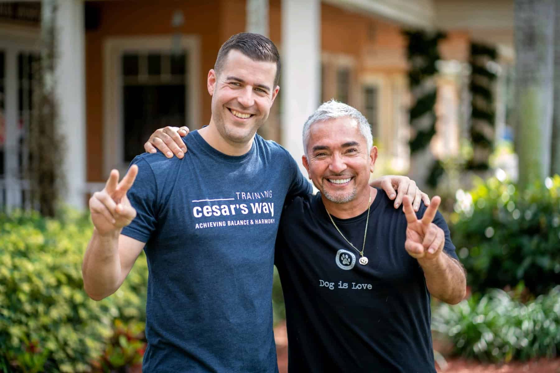 Steve Del Savio and Cesar Millan standing with their arms around each other's shoulders