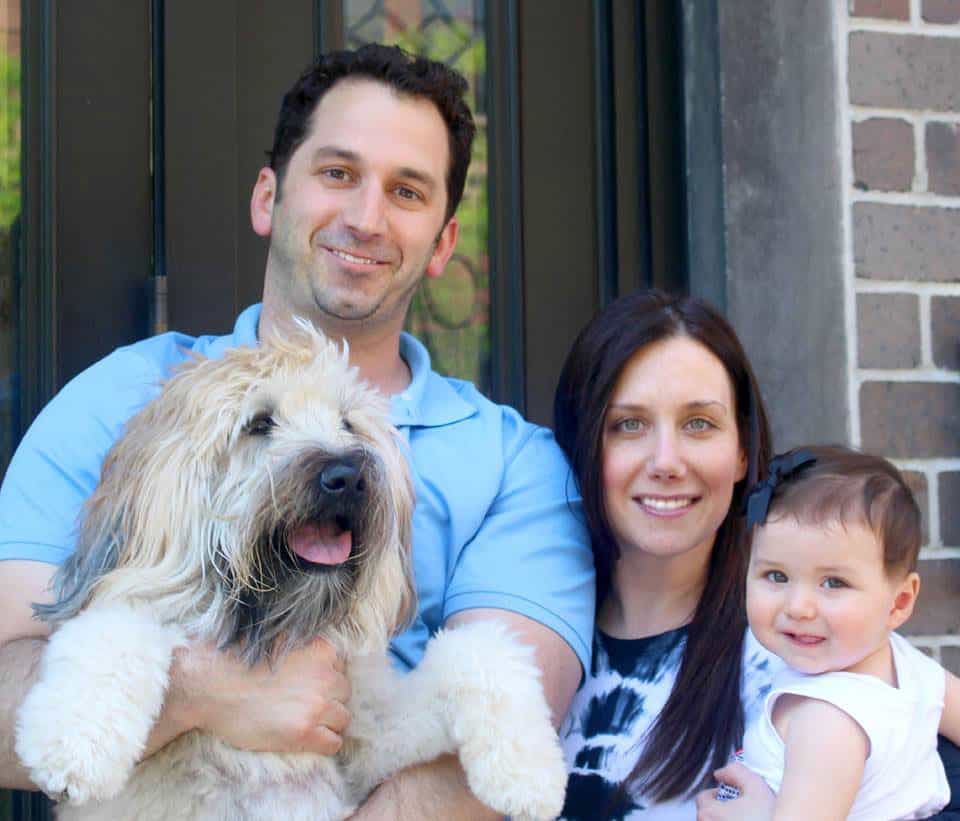 Brooke crouched beside Emmitt, her wheaten terrier, outdoors after his residency.